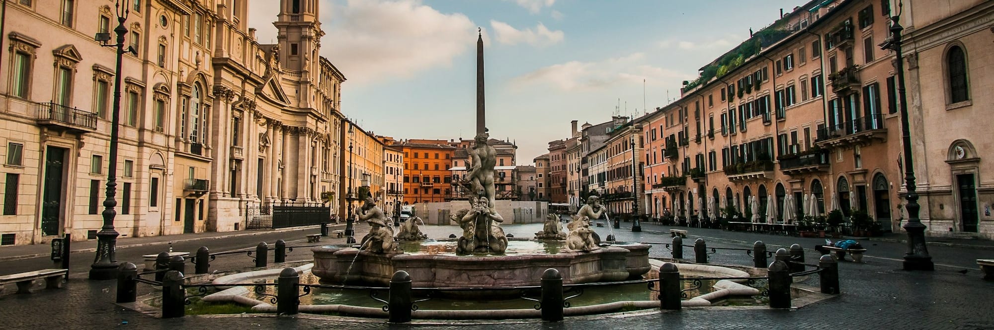 a canal with buildings along it with Piazza Navona in the background