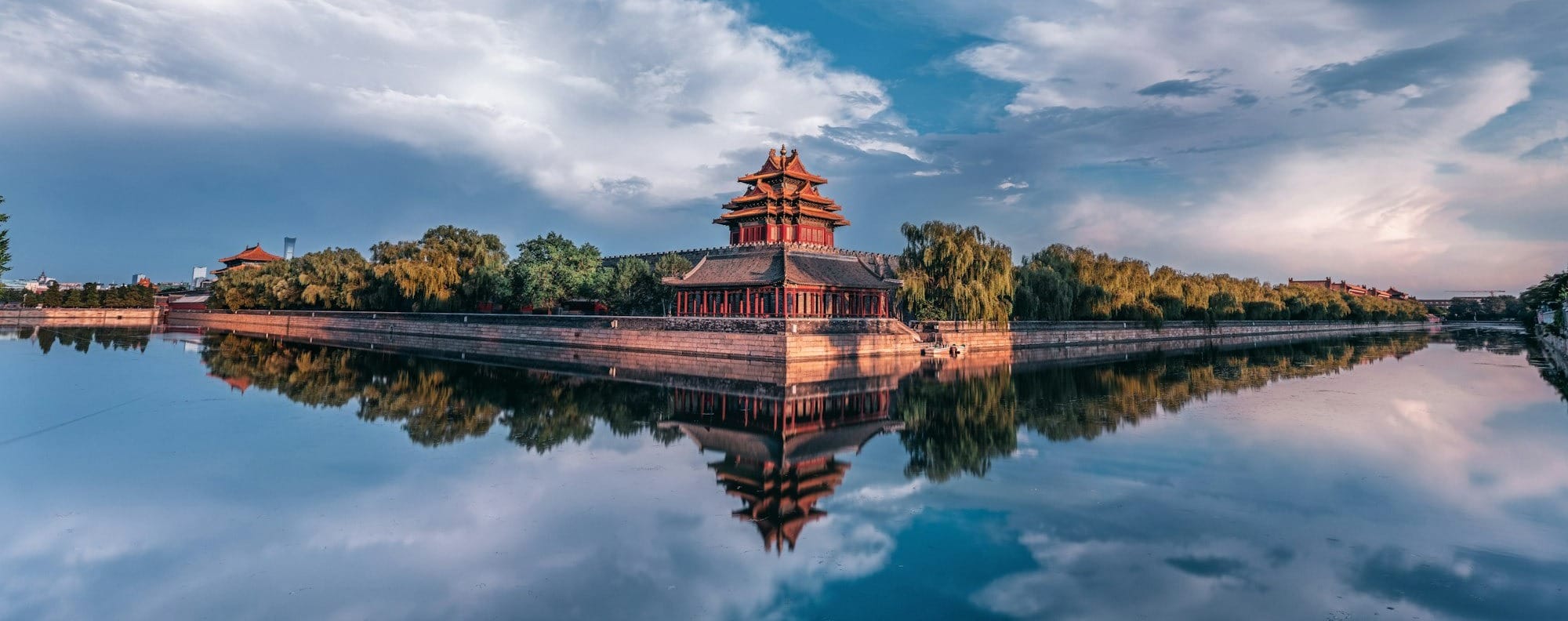brown and green building near body of water under blue sky during daytime